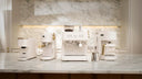 White coffee machine set on a marble countertop with a marble wall in the background