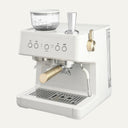 White espresso machine with gold accents on a white background