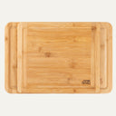 Two rectangular bamboo cutting boards, one large and one medium, with a grooved edge, displayed stacked on top of each other.
